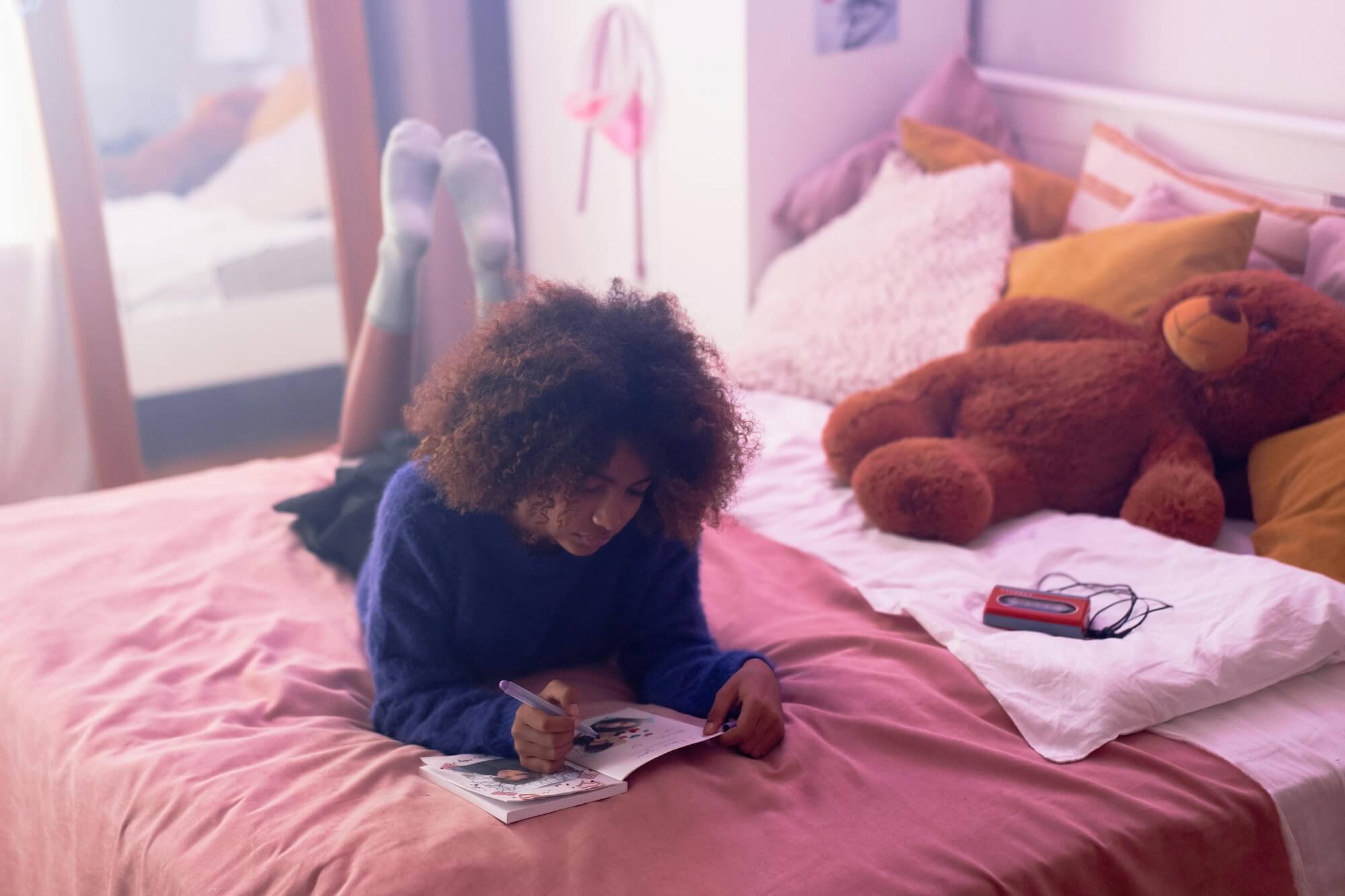 Teen girl journaling in bed