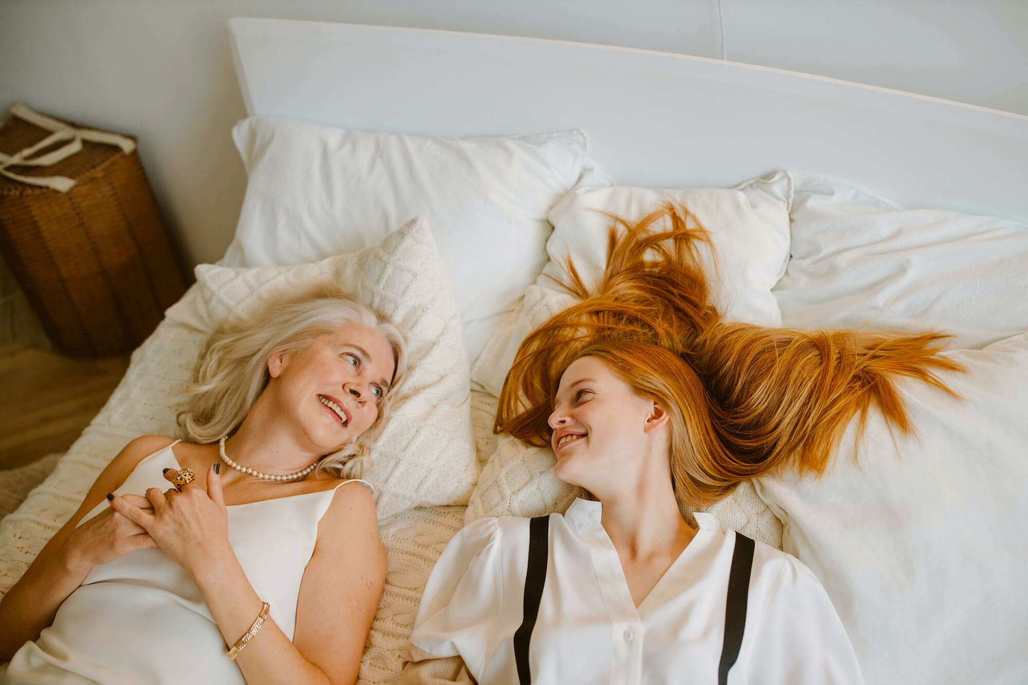Teen and her mom smiling at each other in bed