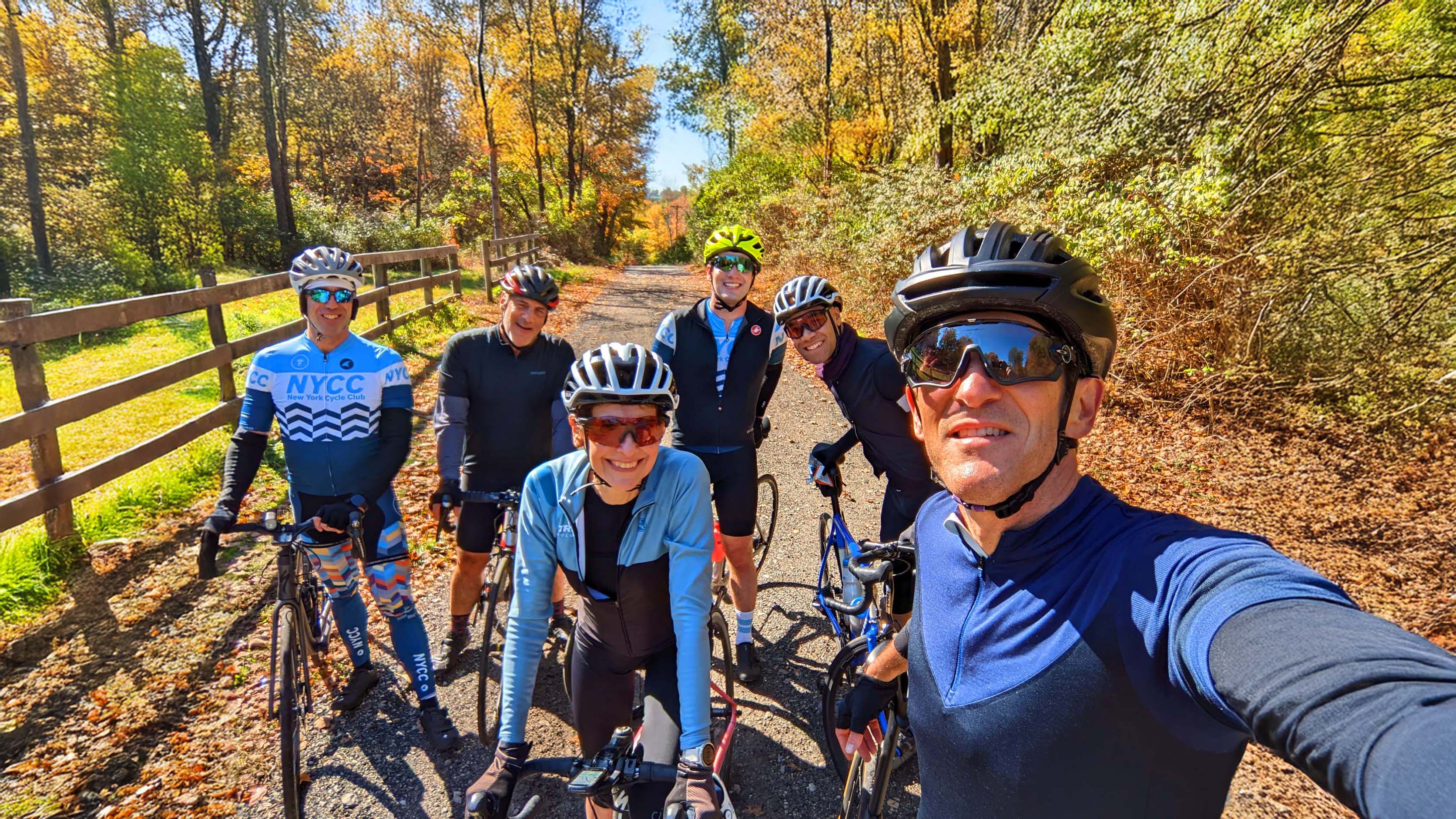 NYCC riders taking a group selfie on a leafy trail in autumn