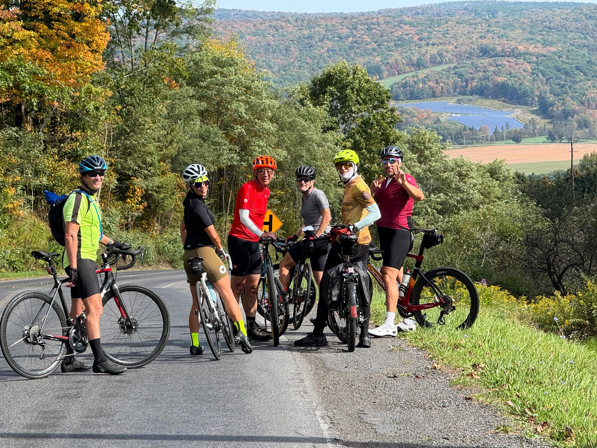 NYCC riders stopped on a hilltop road overlooking autumn farmland