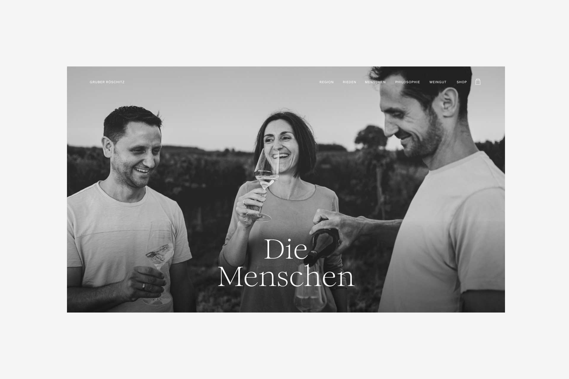 Detail of the section about the people behind the taste, showing the three Gruber siblings standing together on a field drinking a glass of wine