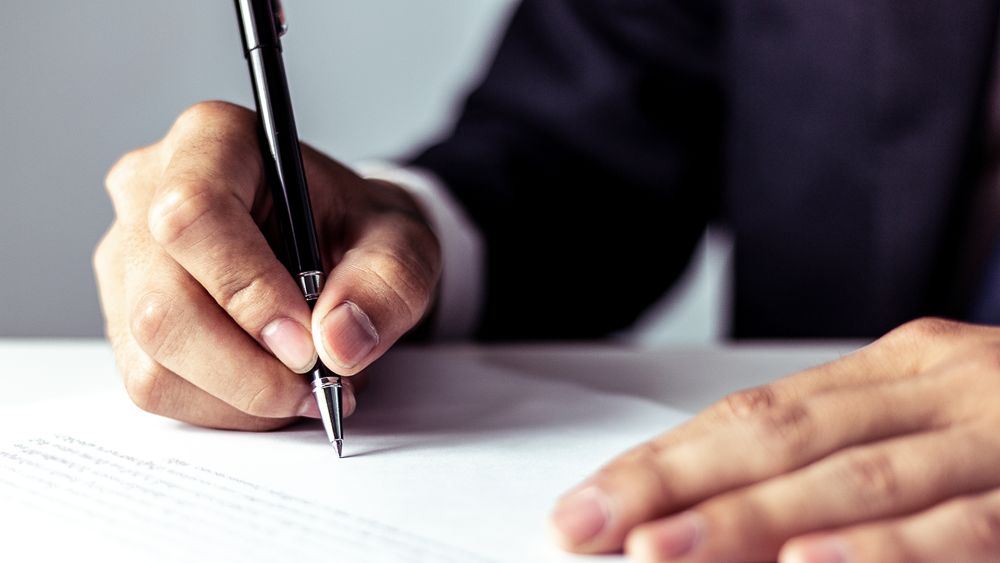 Businessman signing a document at an office desk