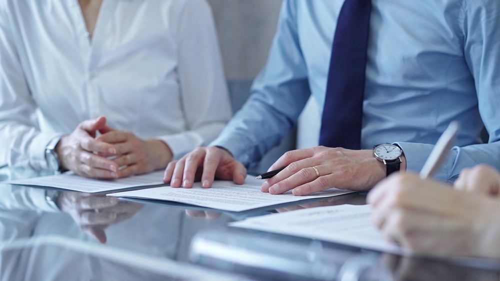 Business people reviewing contract paperwork together