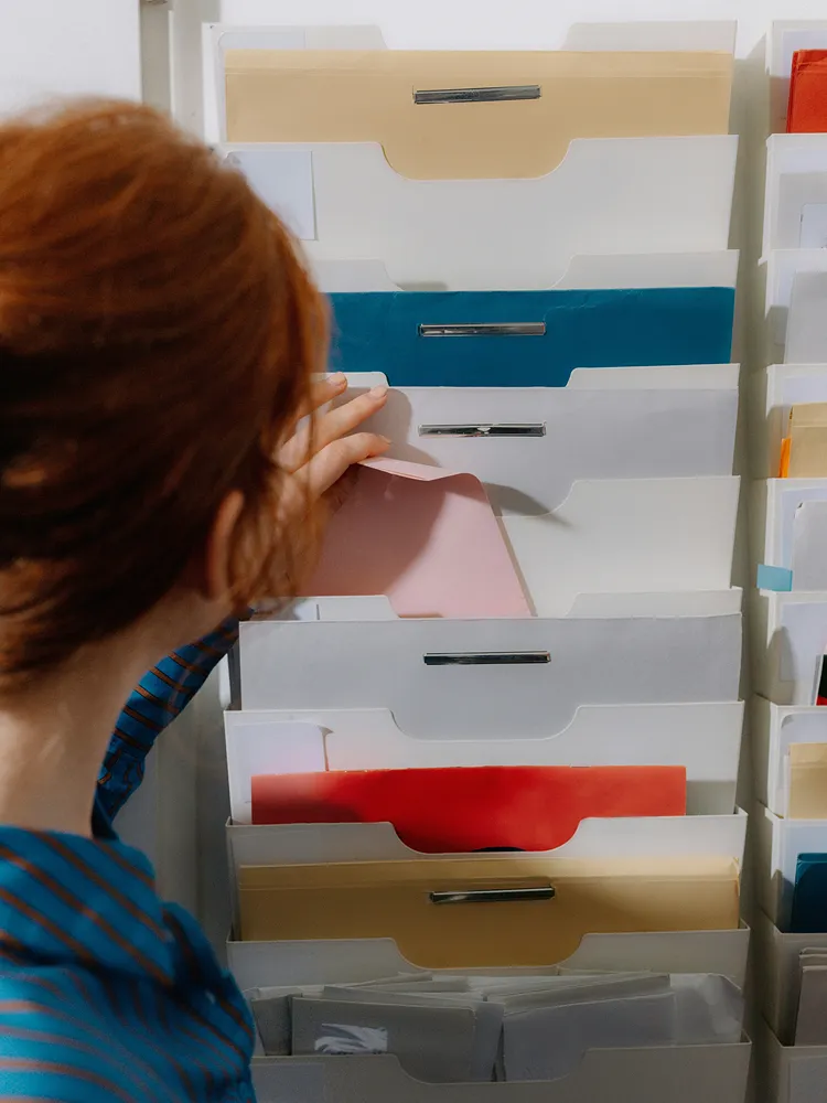 Woman reviewing a stack of office file cabinets