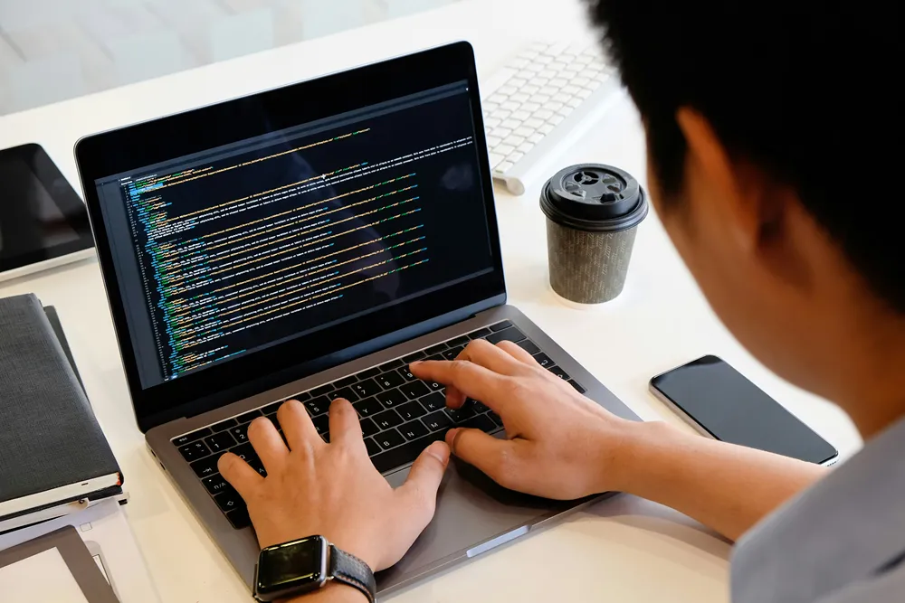 Programmer coding on a laptop