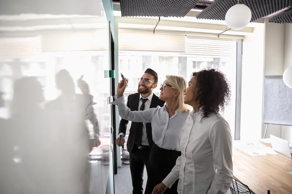 Business development team weighing software options at a whiteboard
