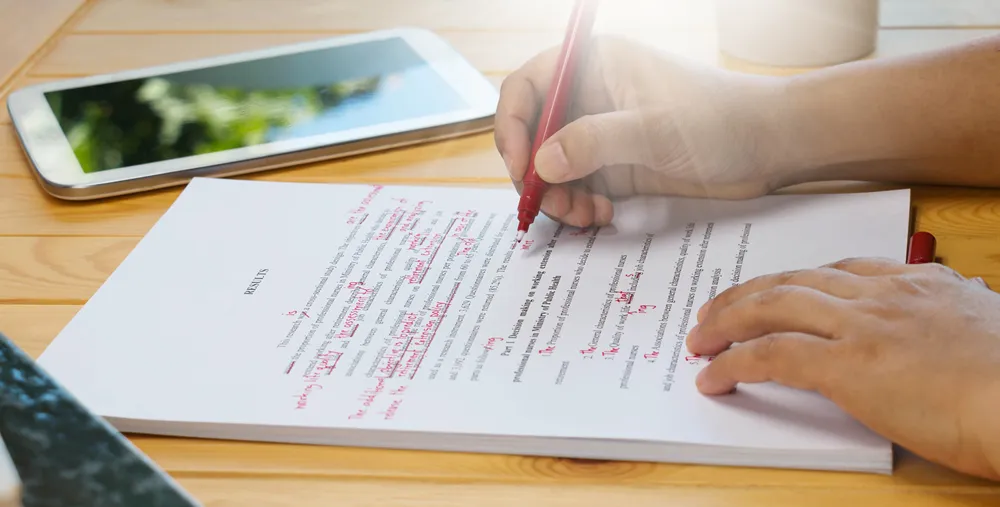 Reviewer marking errors on a printed document with a red pen