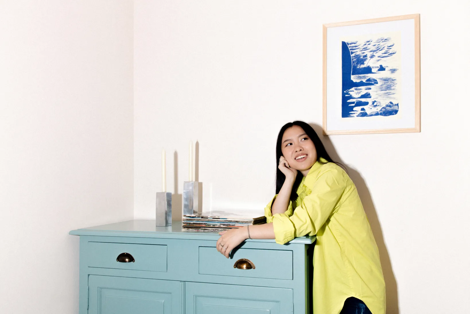 A photograph of a woman leaning on a cabinet 