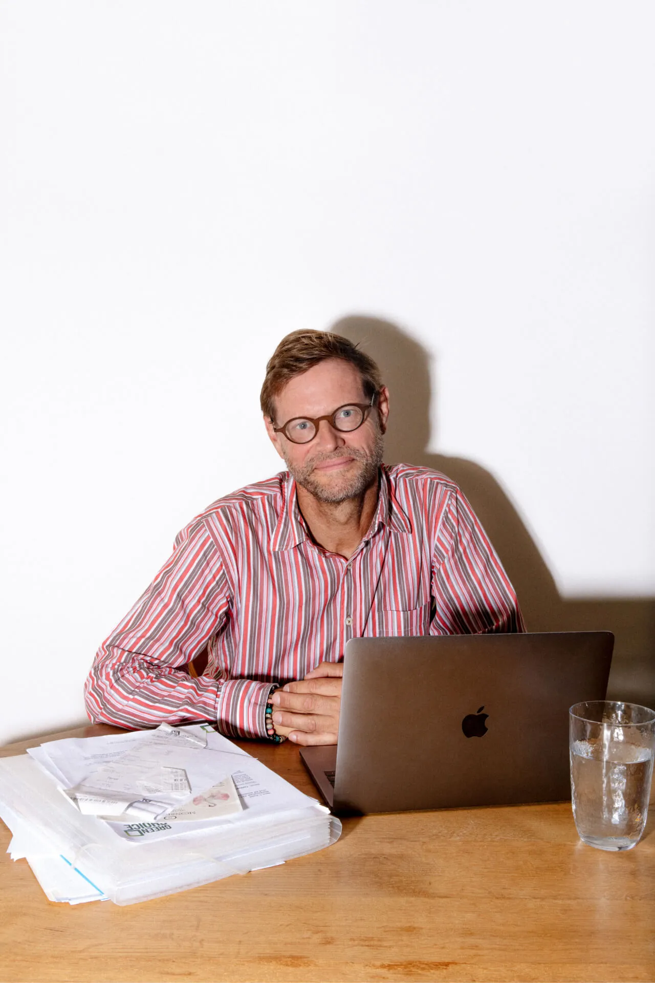 een foto van een man die achter zijn laptop zit