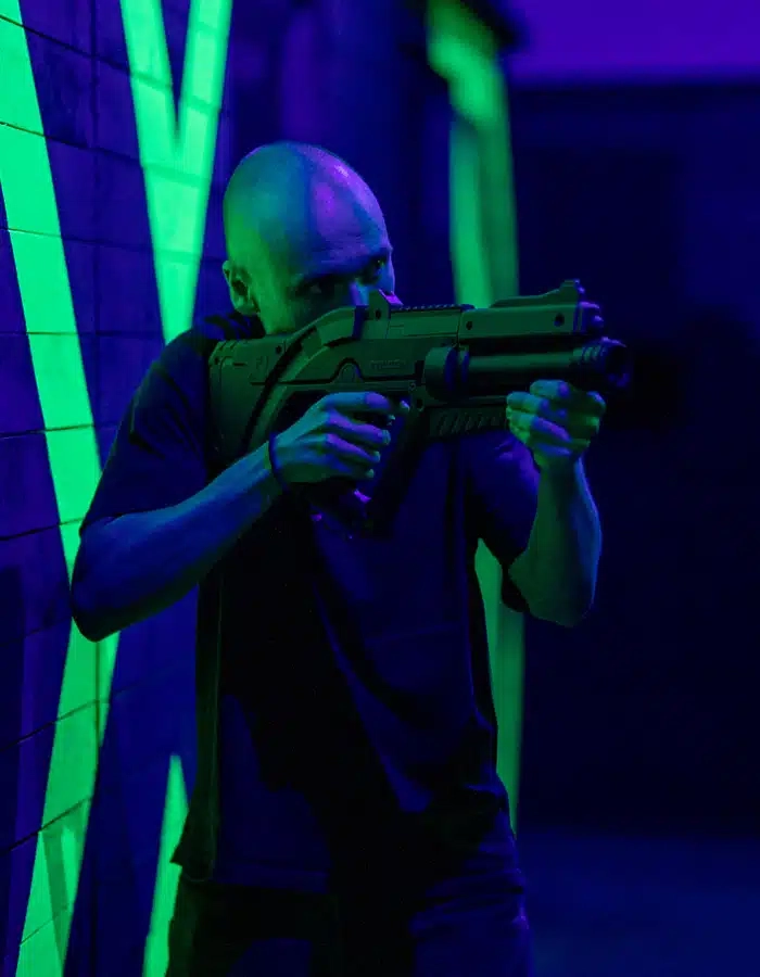 Image d'une personne avec un pistolet de laser game jouant a Pau
