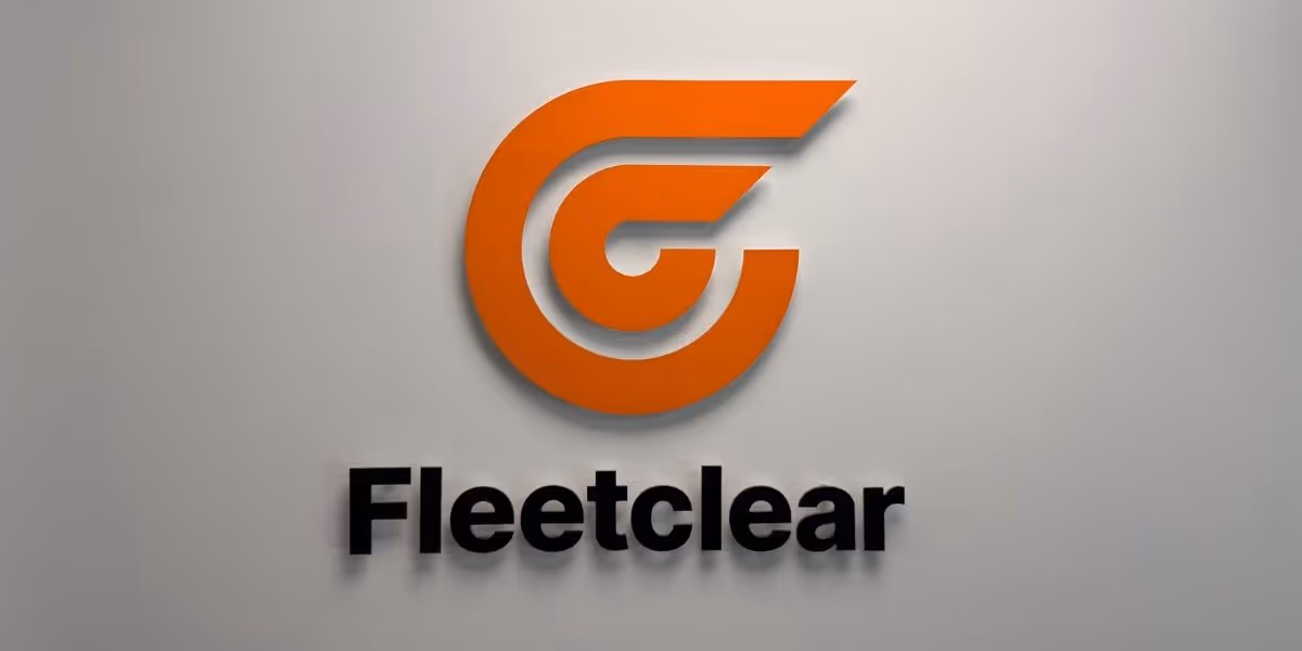Orange Fleetclear Logo on white wall, dim light