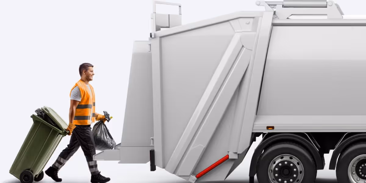 A refuse collector wearing a high-visibility orange vest pulls a green wheelie bin and carries a black rubbish bag towards the rear of a white waste collection lorry.