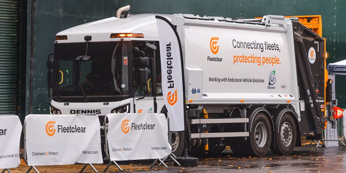 A white refuse collection vehicle fitted with Fleetclear safety technology and branded with the Endurance Vehicle Solutions logo, parked outdoors on a wet track during a Fleetclear OnTrack event.