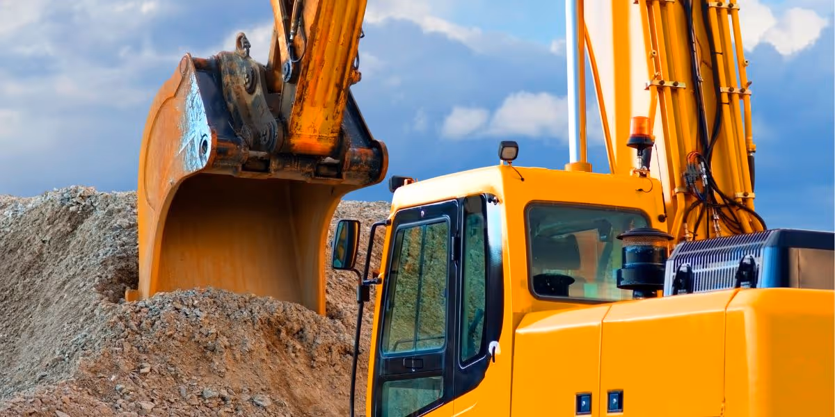 A big yellow digger scooping stones of a big pile.