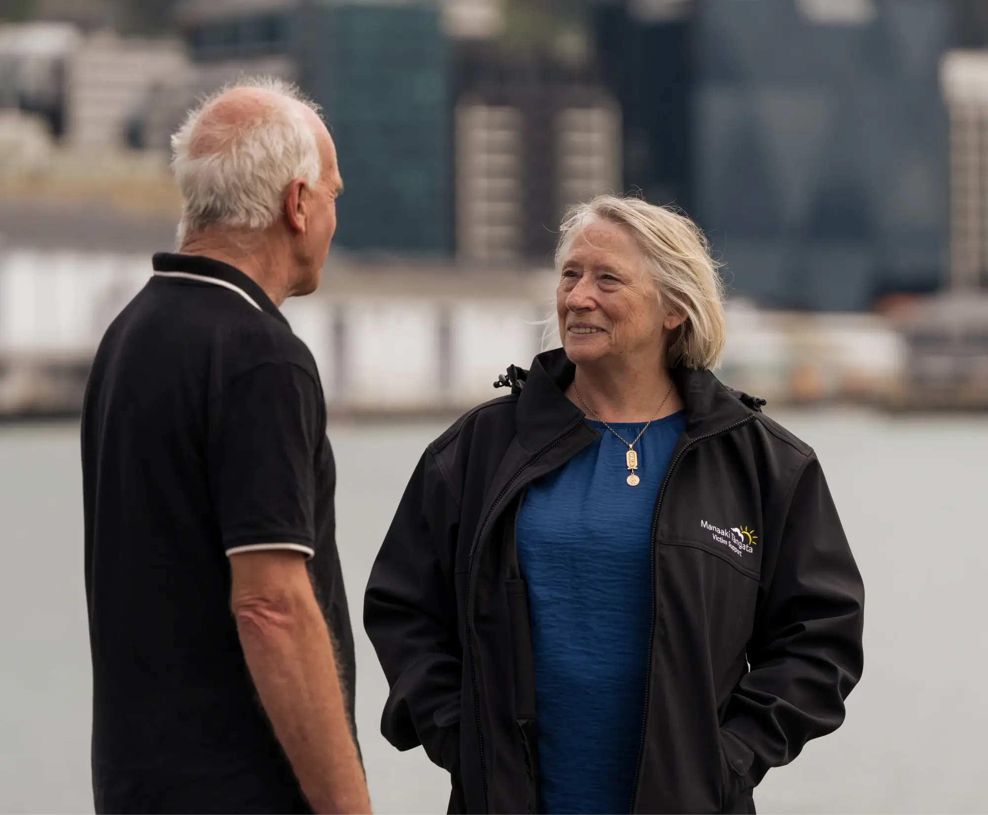 man and woman walking outdoors having conversation.