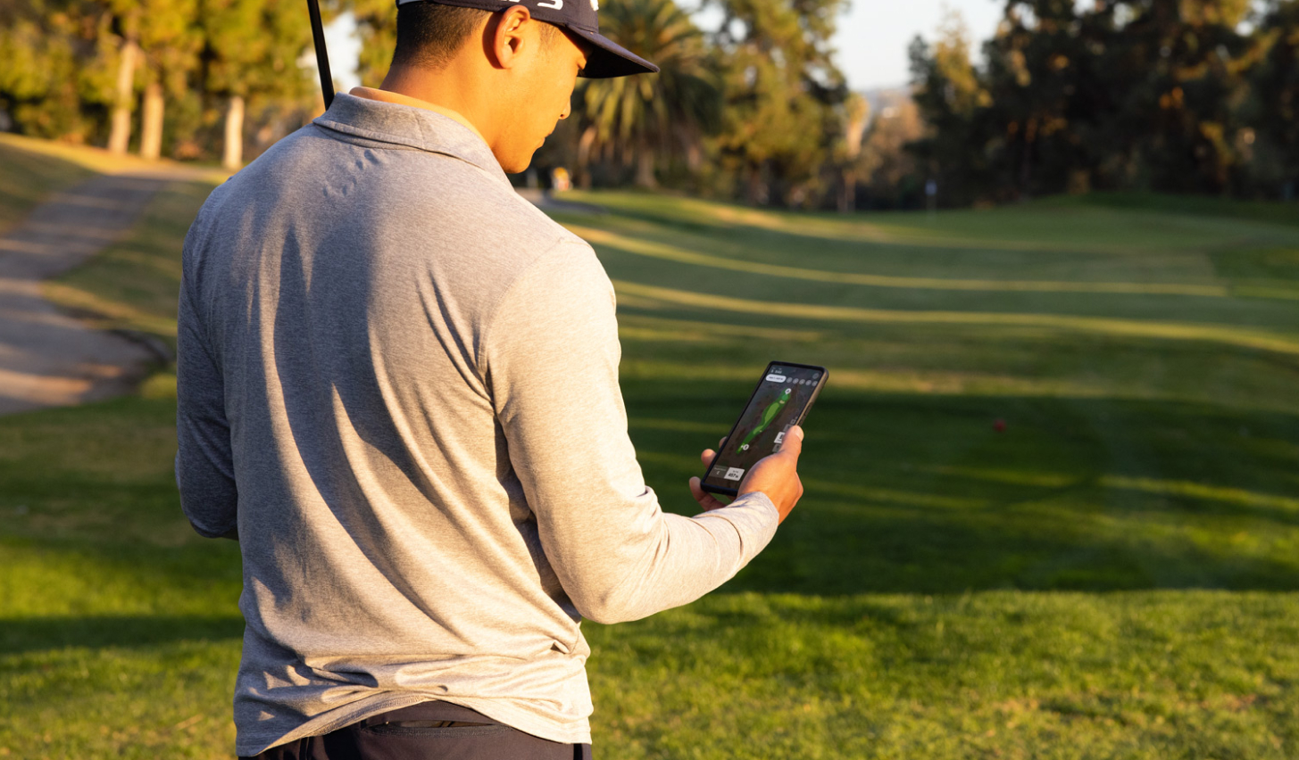 A man looking at the golf tracking app
