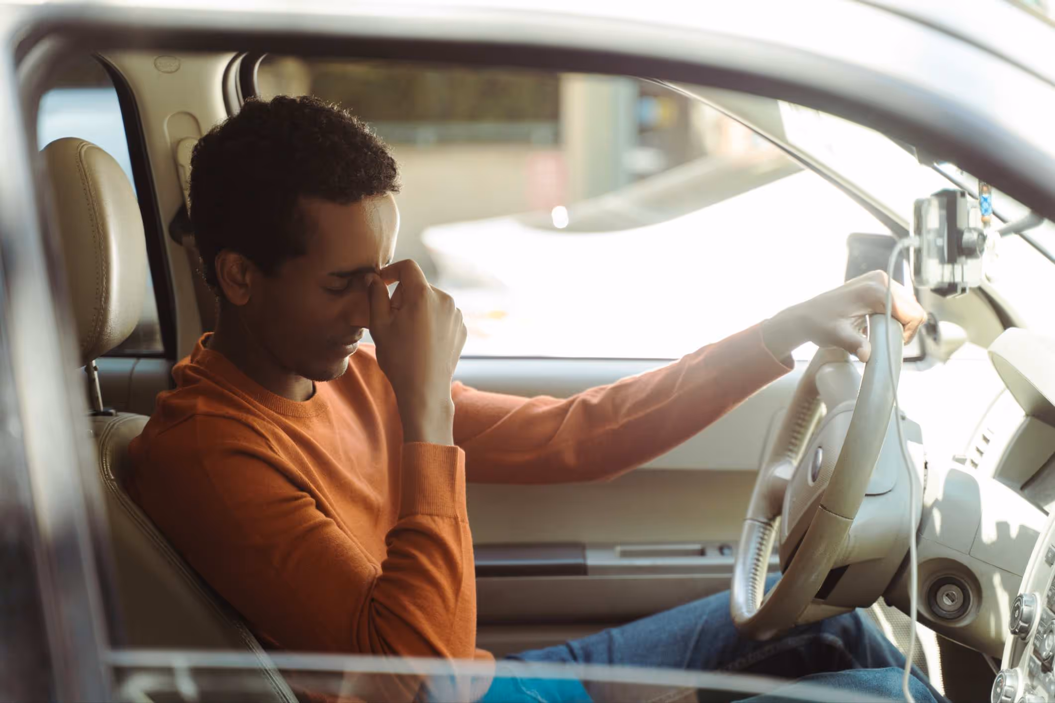A young African American man has just been in an accident. He’s preparing to call his San Diego car accident attorney.