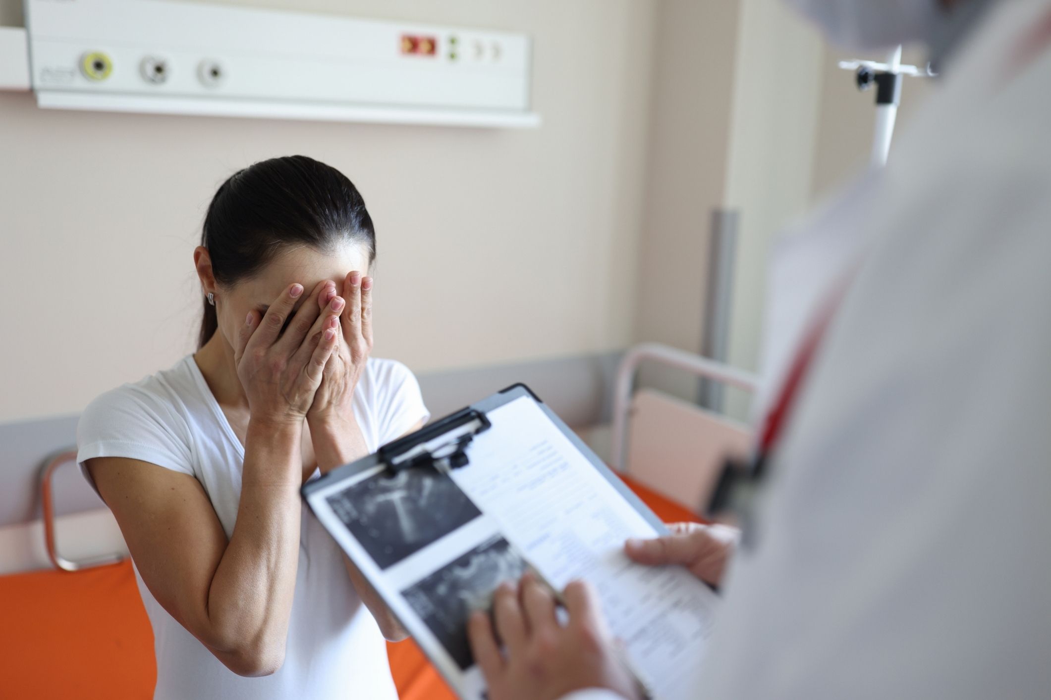 Doctor reviewing paperwork with upset patient, representing La Mesa medical malpractice lawyer cases.