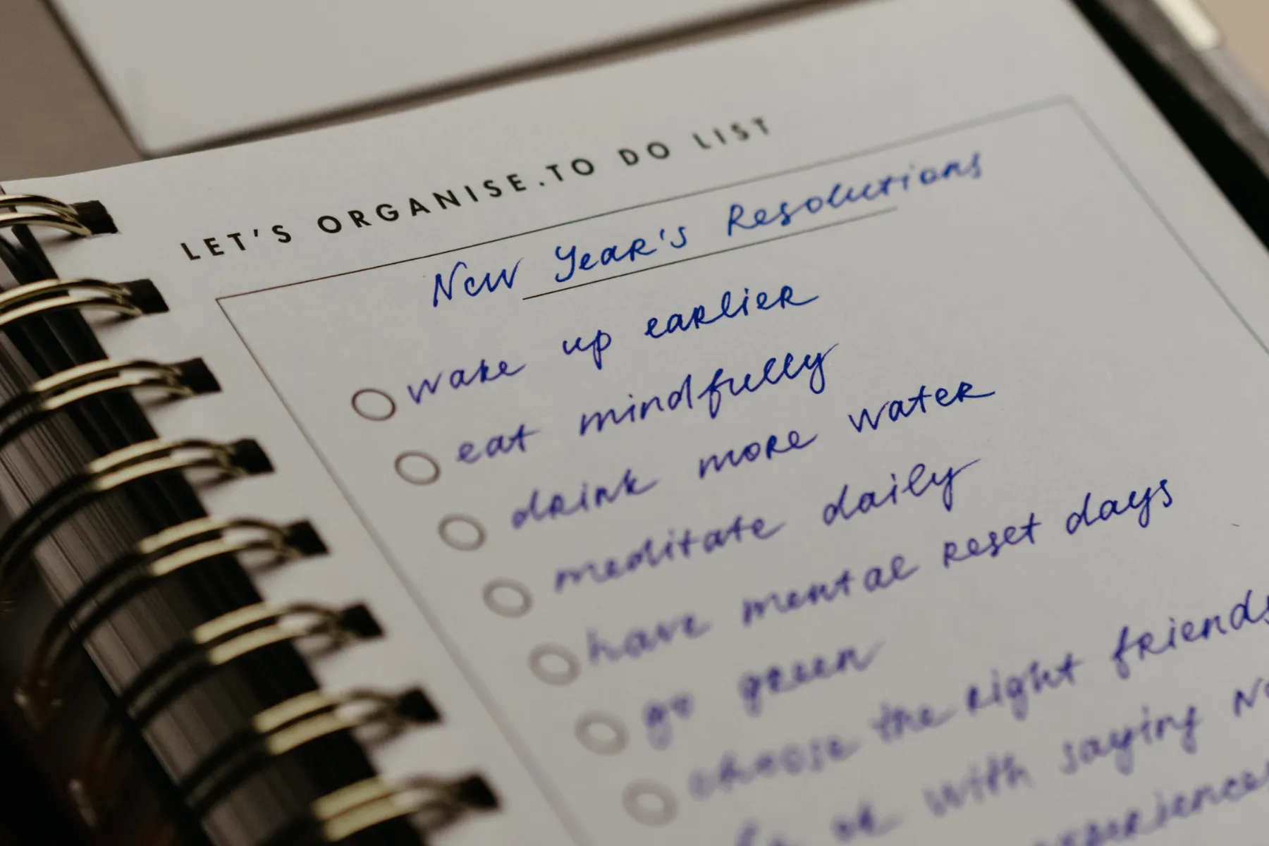 Handwritten New Year's resolutions list including wake up earlier, eat mindfully, drink more water, meditate daily.