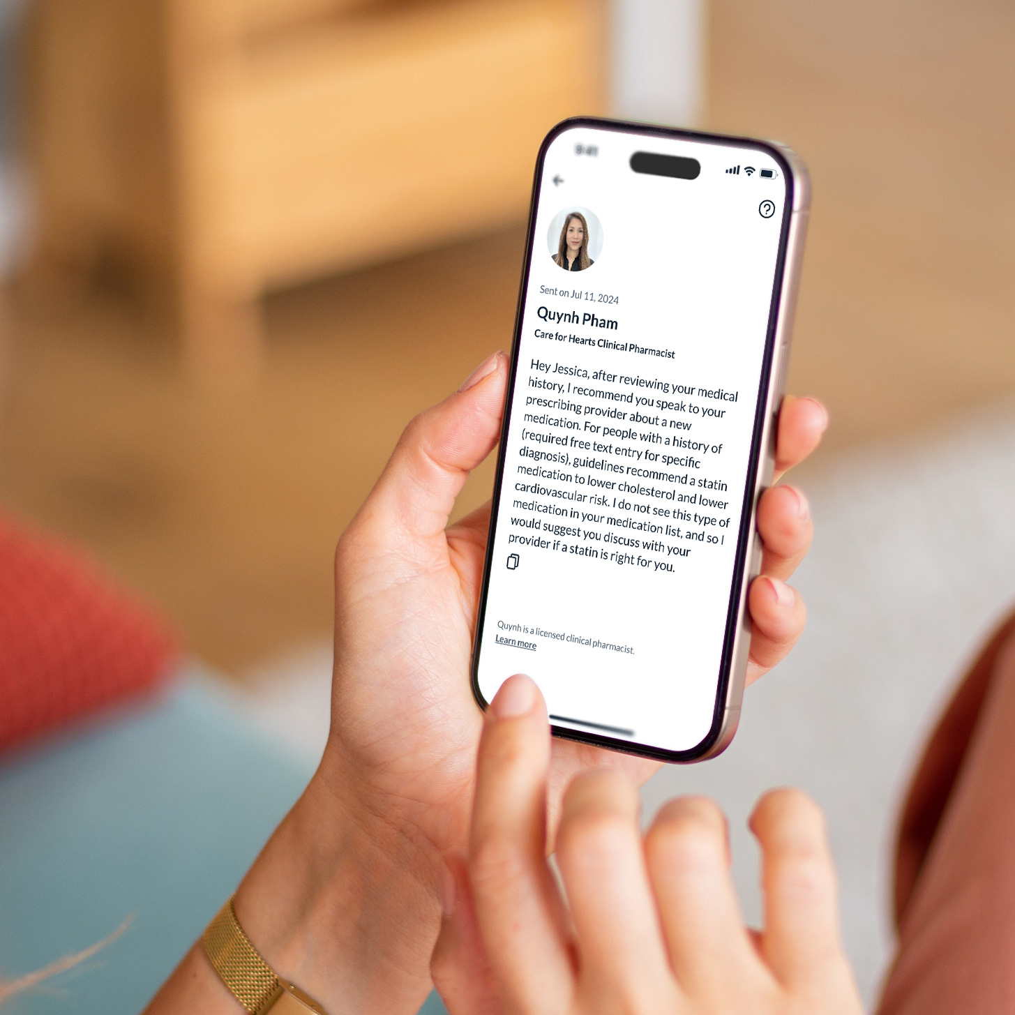 Hand holding a smartphone displaying a clinical pharmacist's message about medication recommendation.
