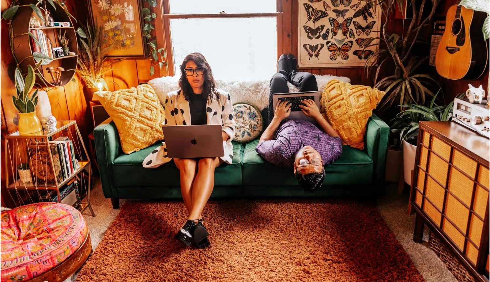 Jess and Nelson sitting on a couch with their laptops