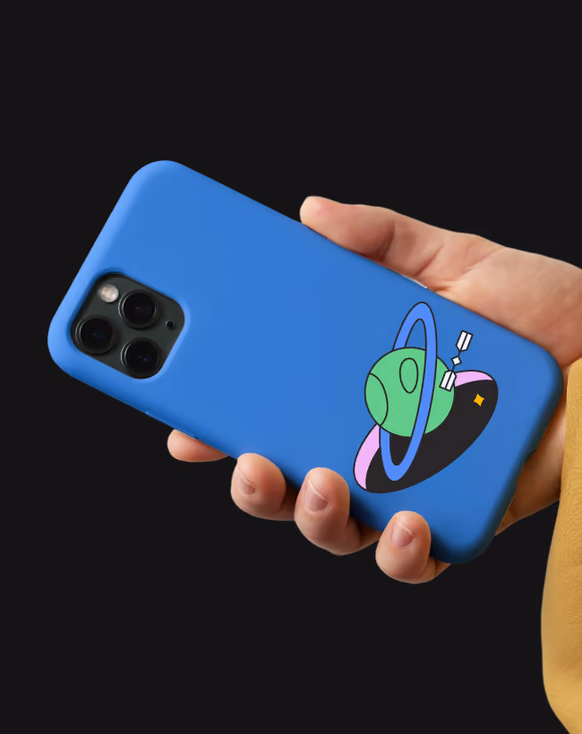 Hand holding blue phone case with a colorful cartoon alien and planet design on the back.