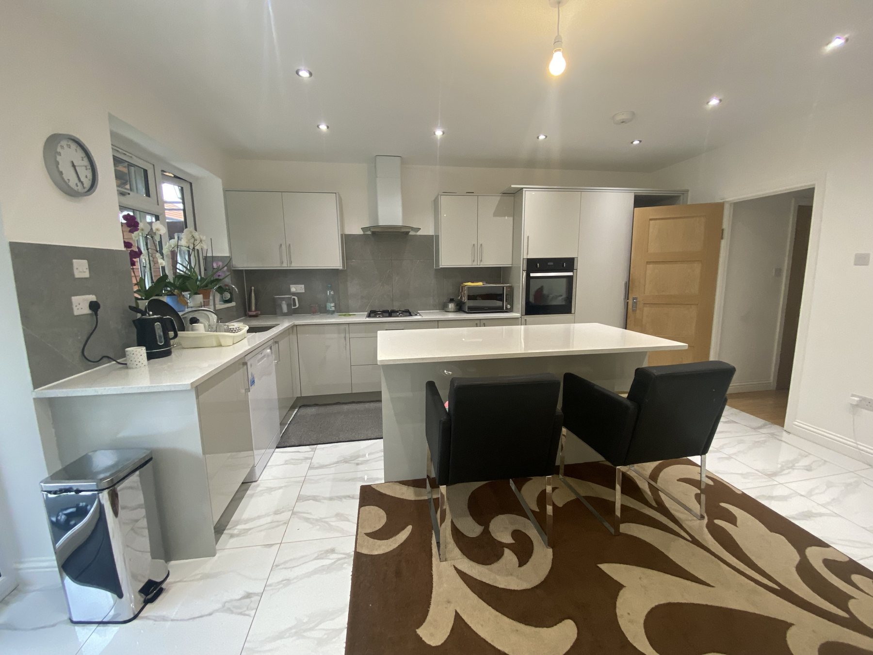 A rear extension and new kitchen on a semi-detached house in Northolt, with a long run of gloss units, a breakfast island and a new downstairs WC.