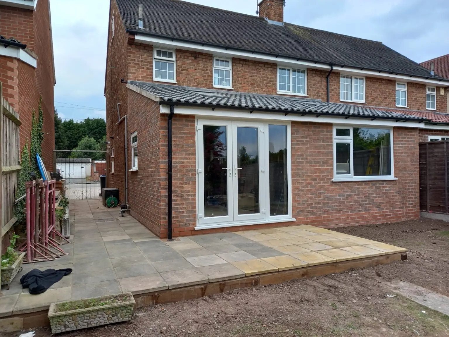 A single-storey rear extension in Southall built in matching brick, with a new patio and glazed doors onto the garden.