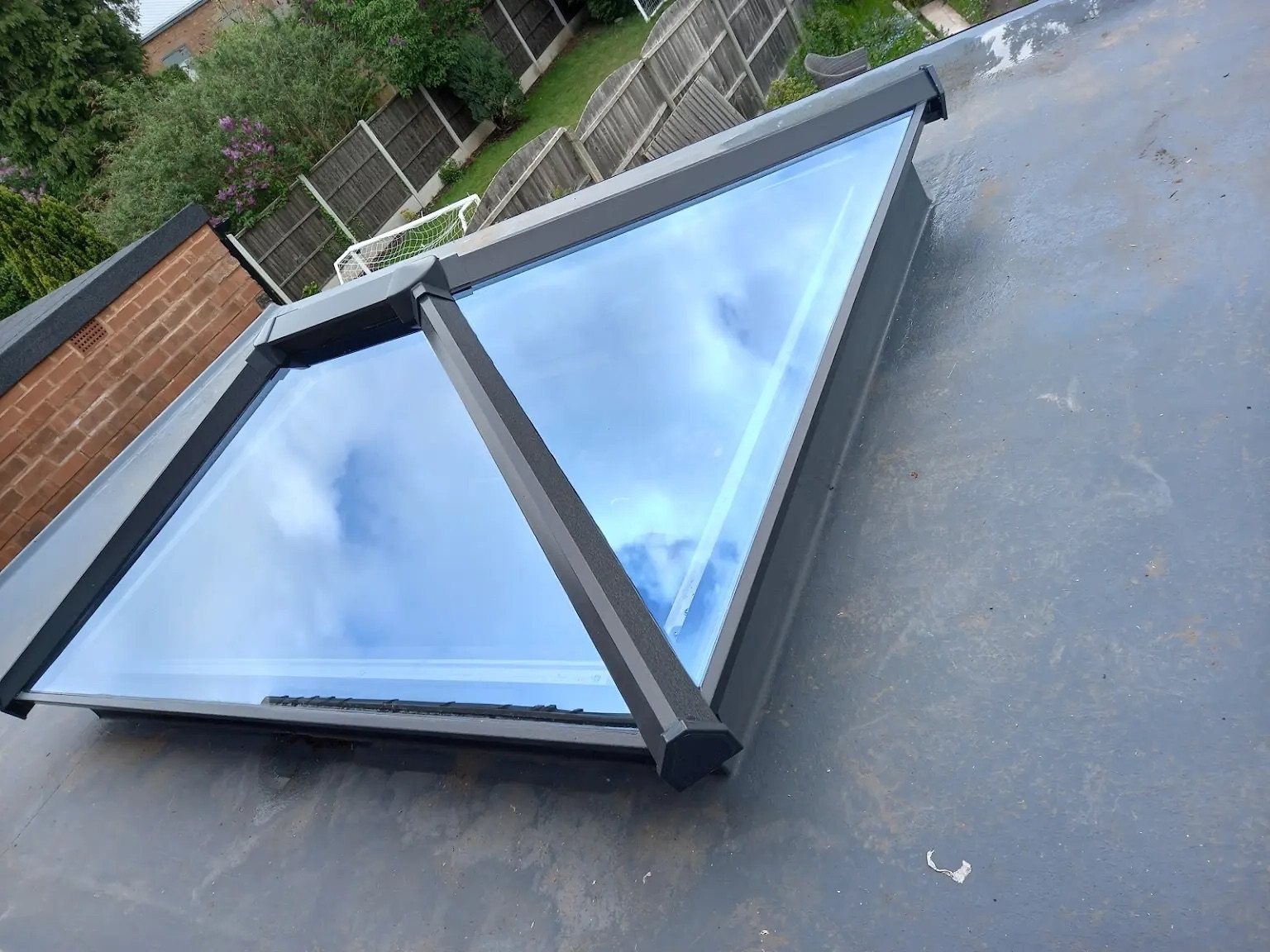 A rear extension on a 1930s house in Staines: new drainage and foundations, insulated slab, cavity walls, steel over the opening and a flat warm roof with a roof lantern.