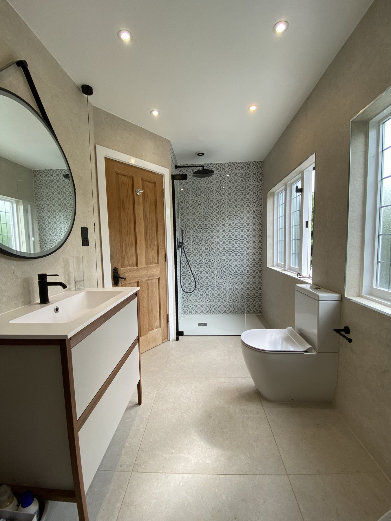 Shower room with black fittings and round mirror