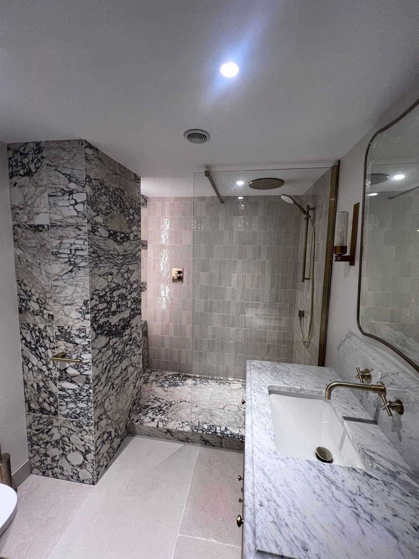 Marble-effect walk-in shower with brass fittings
