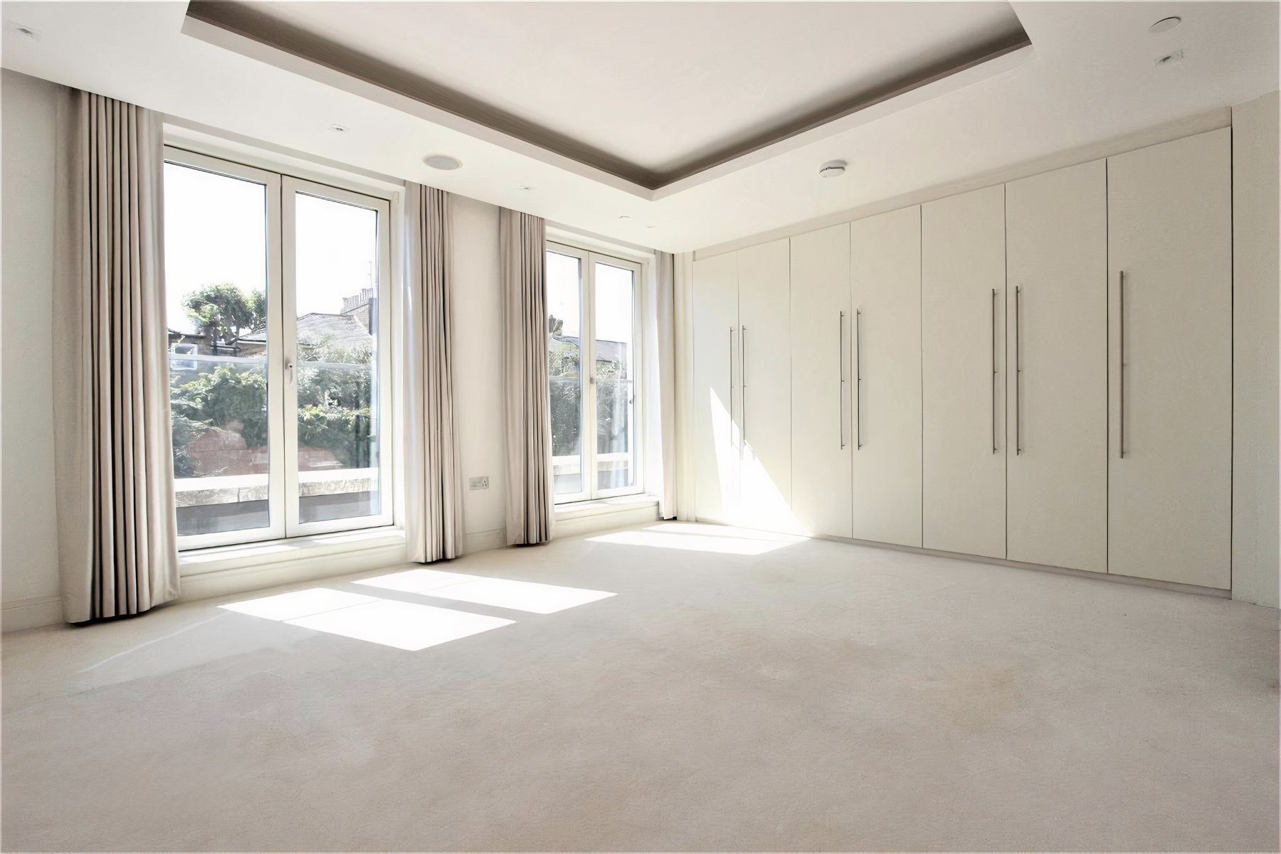 Finished rooms from recent renovations: fitted wardrobes and coffered ceilings in a bedroom, and a living room with oak flooring, a panelled chimney breast and sliding doors to the garden.