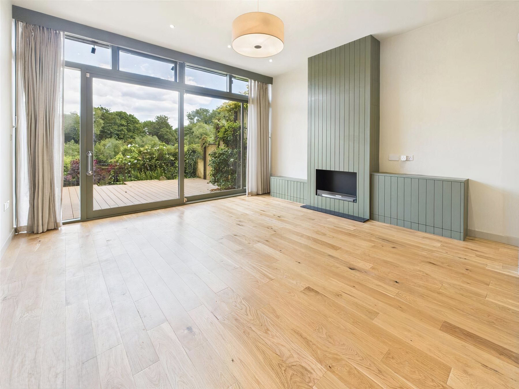 Living room with oak flooring and panelled chimney breast
