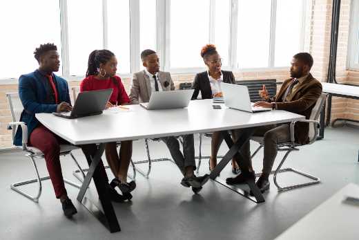 A public-sector finance team meeting around a table with laptops