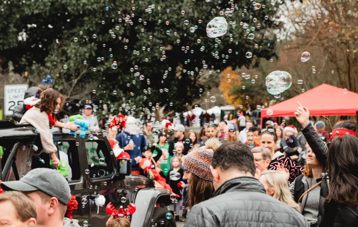 Neighbors line the streets of Lanier Blvd to watch the Winterfest motor parade.