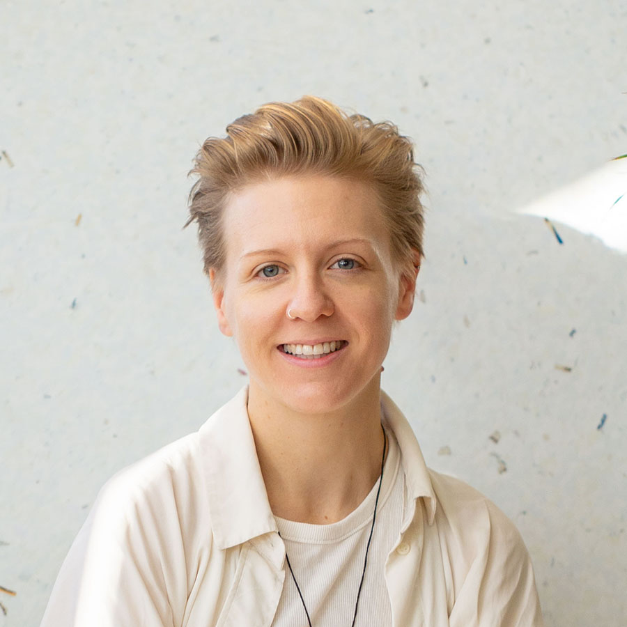 Jo Barnard smiling, wearing a cream open-collar shirt.