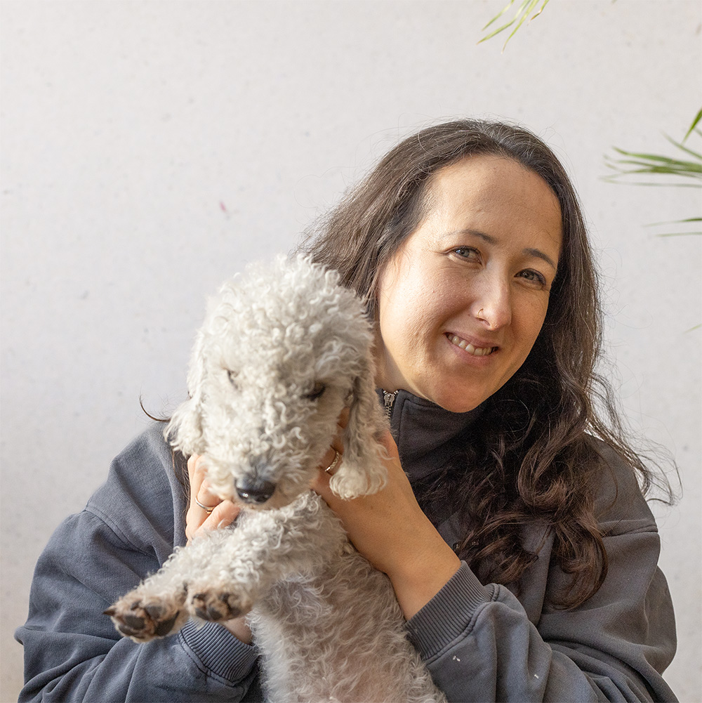 Elizabeth smiling at the camera holding the office dog Penny