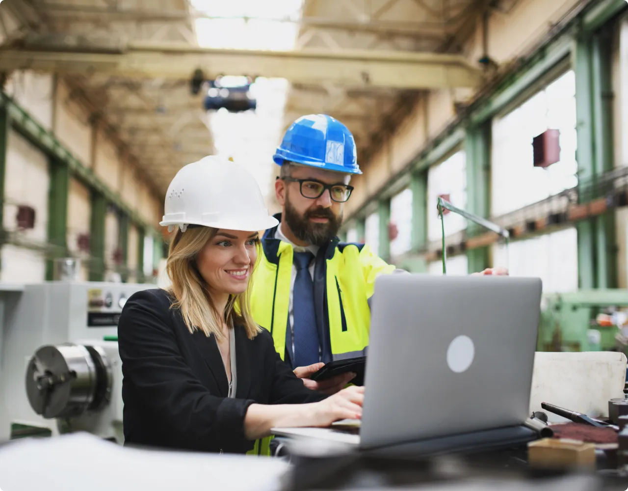 Woman engineer showing something to man on laptop