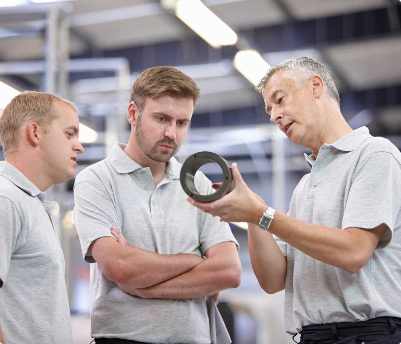 Engineer explaining component part to other egineers