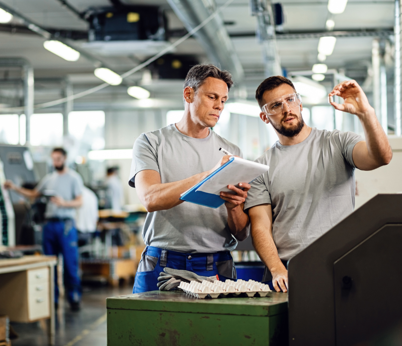 Two men checking quality of the product in factory