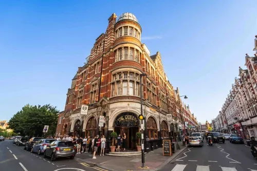 Nestled in the heart of Crouch End, The Queens is a Grade II* listed Victorian gem that has long been a social hub for the community. This iconic building, with its stunning nouveau stained glass, intricate plasterwork, and rich dark wood paneling, exudes timeless charm and character. The Queens offers a warm welcome to locals, regulars, and newcomers alike. Whether you’re stopping by for a drink, a meal, or simply to soak in the historic atmosphere, The Queens is a true landmark in the vibrant urban village of Crouch End.