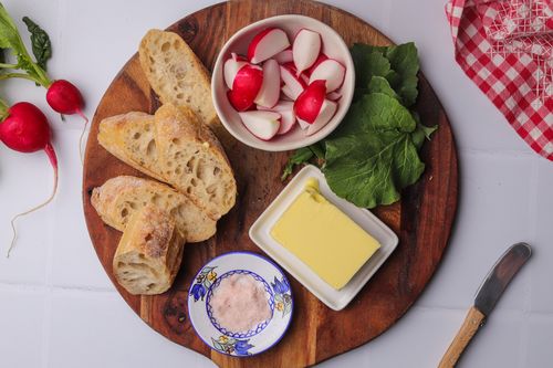 Serving board with radishes, butter and bread