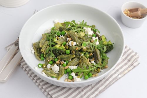 Bowl of super green pasta topped with rocket