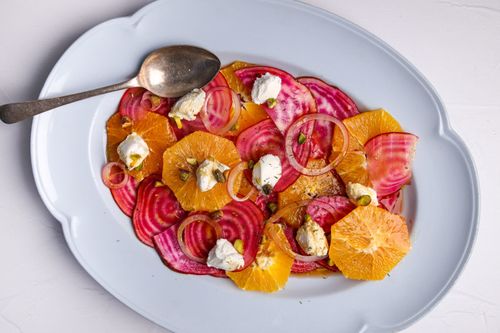 White serving platter with beetroot salad layered on top