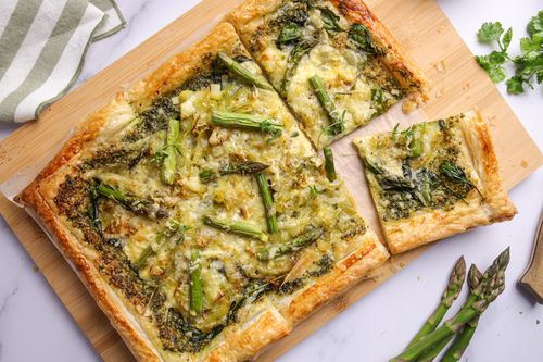 Sliced asparagus puff pastry tart on a board