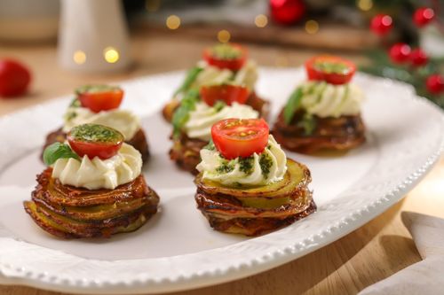 Mini courgette and potato stacks on a serving platter