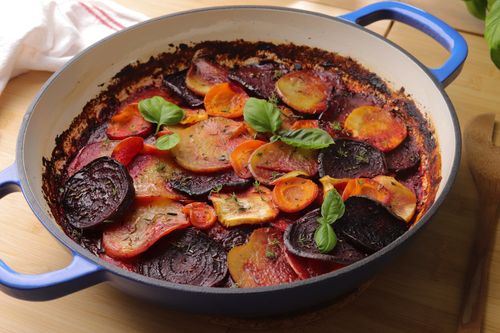 A baked root vegetable ratatouille layered with beetroot, parsnip, carrot and potato, topped with Parmesan and bubbling tomato sauce.