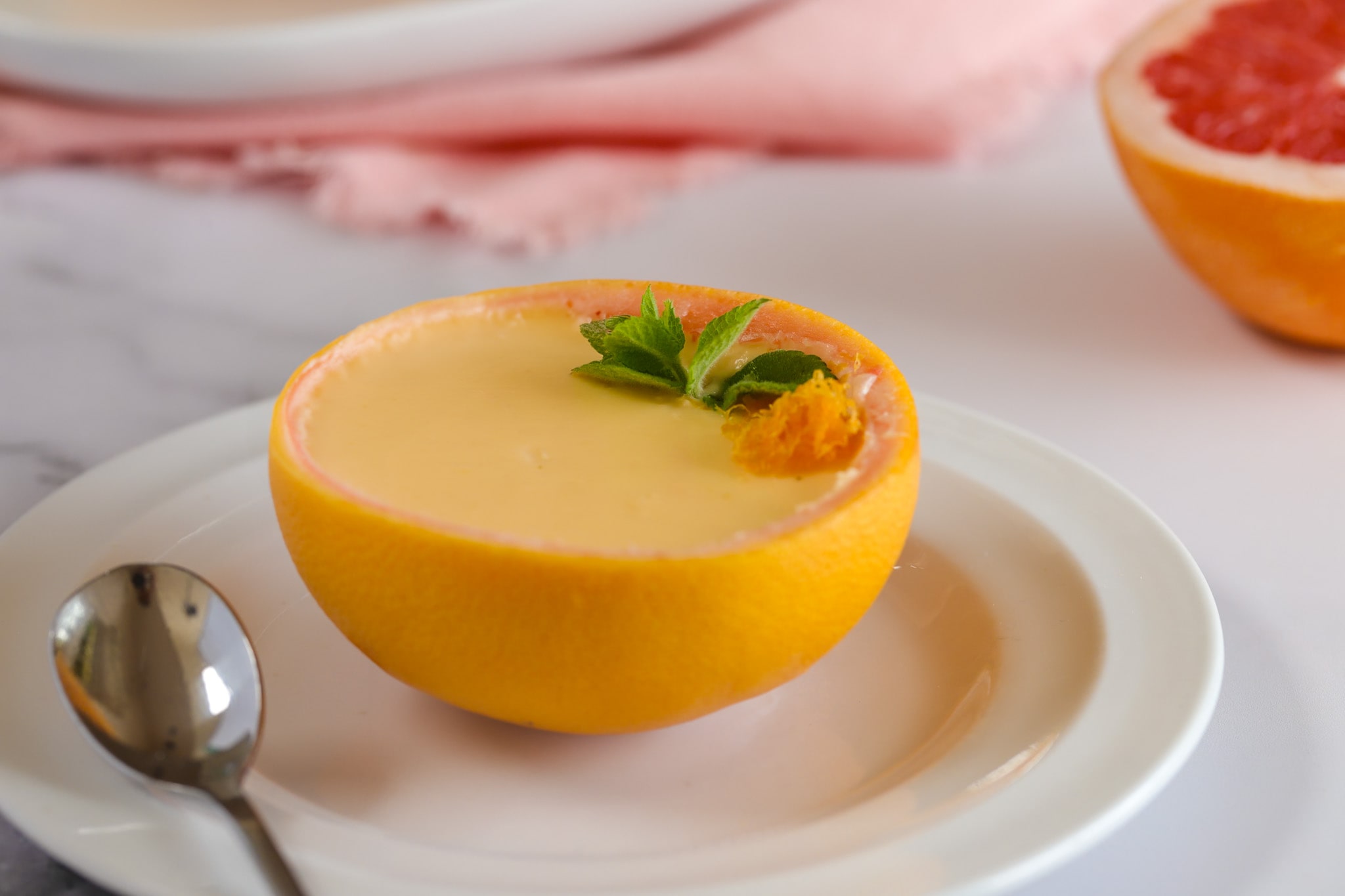 Creamy grapefruit posset set in grapefruit skins, chilled and zesty with a silky citrus finish.