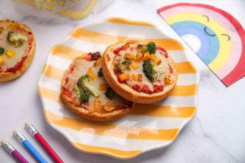 Mini veggie pizza muffins baked on English muffins, topped with broccoli, pumpkin, and cheese - a fun after-school snack or lunchbox treat.