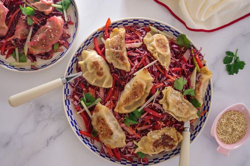 Pork dumplings served over a vibrant shredded salad with beetroot, cabbage and sesame dressing – colourful, crunchy, and satisfying.